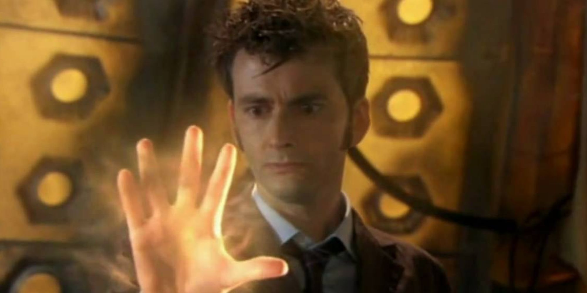 David Tennant as the Tenth Doctor staring at his glowing hand
