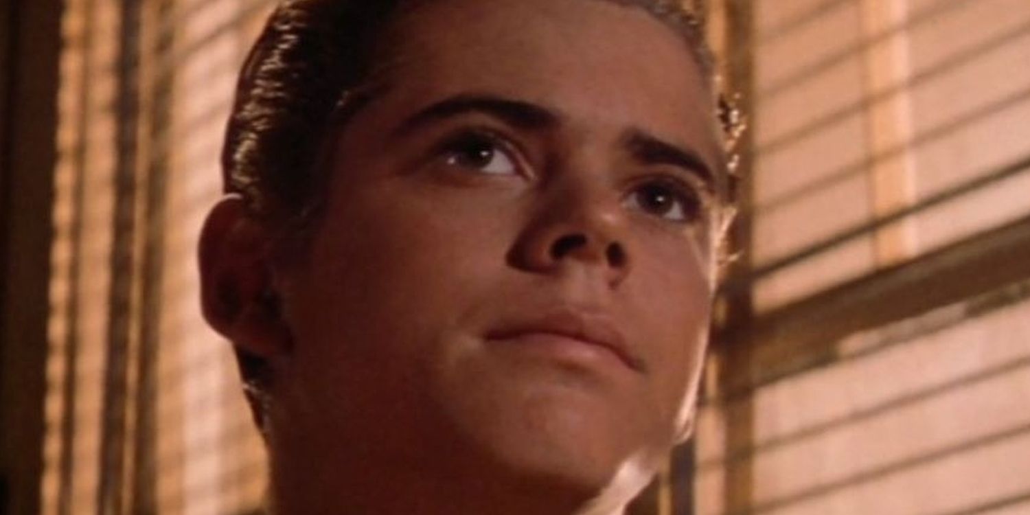 Ponyboy looking by a window in The Outsiders