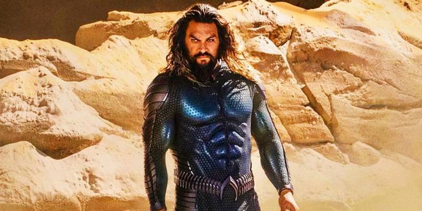 Aquaman (Jason Momoa) in a blue costume on a beach in Aquaman and the Lost Kingdom