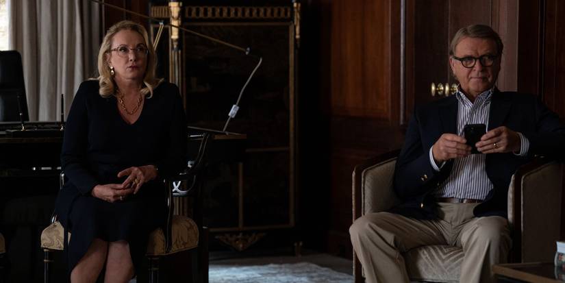 Gerri (J. Smith-Cameron) and Karl (David Rasche) sitting in chairs looking concerned in Succession season 4 episode 4 Honeymoon States.