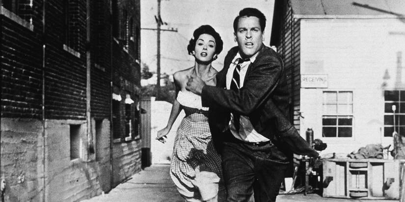 Kevin McCarthy and Dana Wynter in Invasion of the Body Snatchers both running away from the unseen monsters