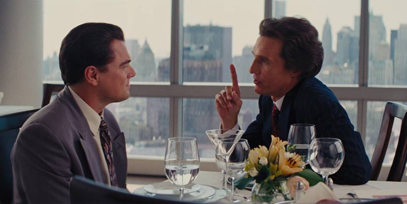 Jordan and Mark talking at a table in The Wolf of Wall Street