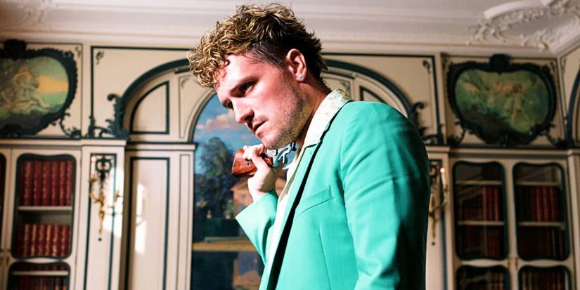 Josh Hutcherson como Derek Danforth em um terno verde em O Apicultor