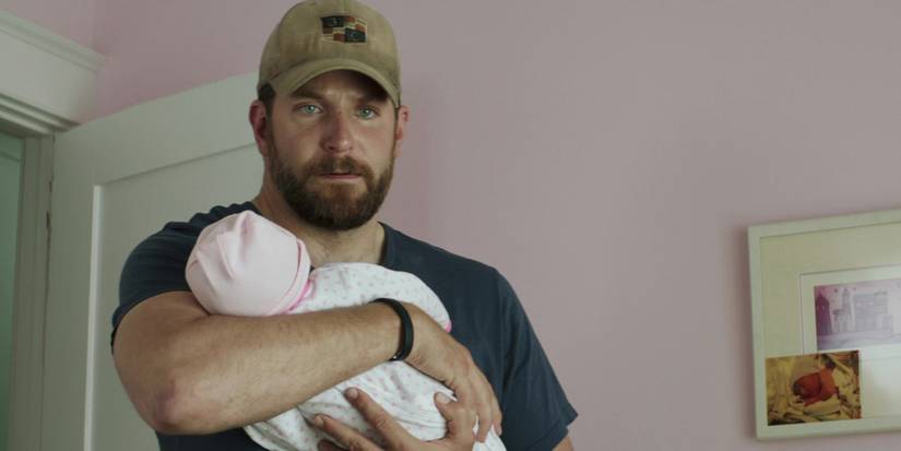 Chris Kyle (Bradley Cooper) holding his baby in American Sniper