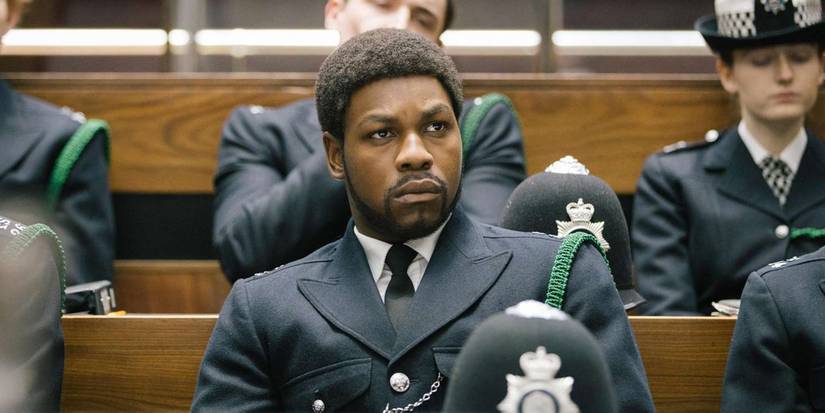 Leroy Logan (John Boyega) sitting among his fellow police Officers in Red, White, and Blue