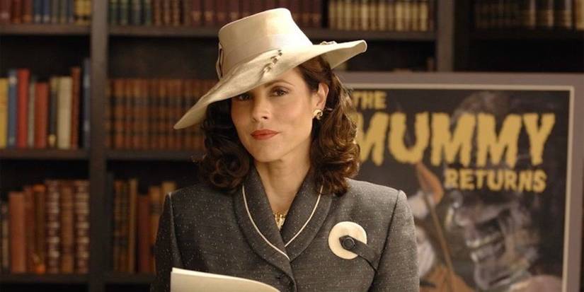 Evelyn O'Connell (Maria Bello) steht mit einem aufgeschlagenen Buch vor einem "Mama kehrt zurück" Poster 