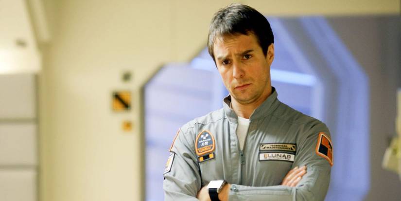 Sam Rockwell with his arms crossed in the space station in Moon
