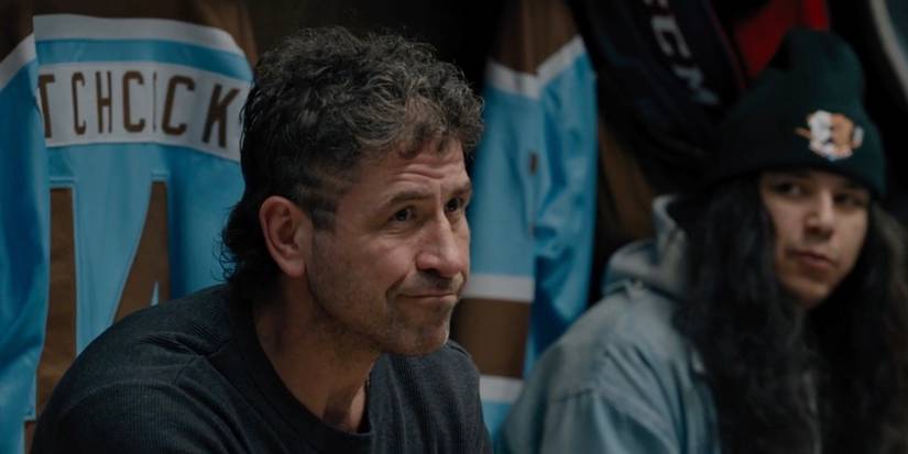 Ted sitting in front of his jersey in the locker room.