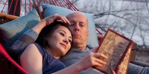 Bruce Willis as Old Joe in Looper with Xu Qing as Old Joe's wife as they read a book together in a hammock