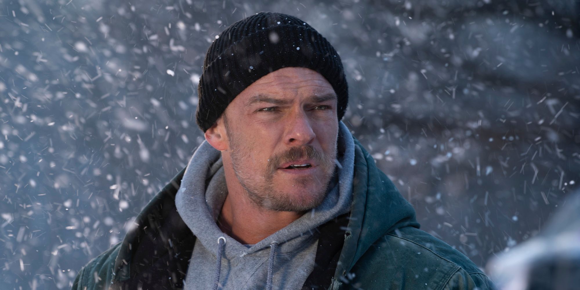 Alan Ritchson stands in the snow in Ordinary Angels