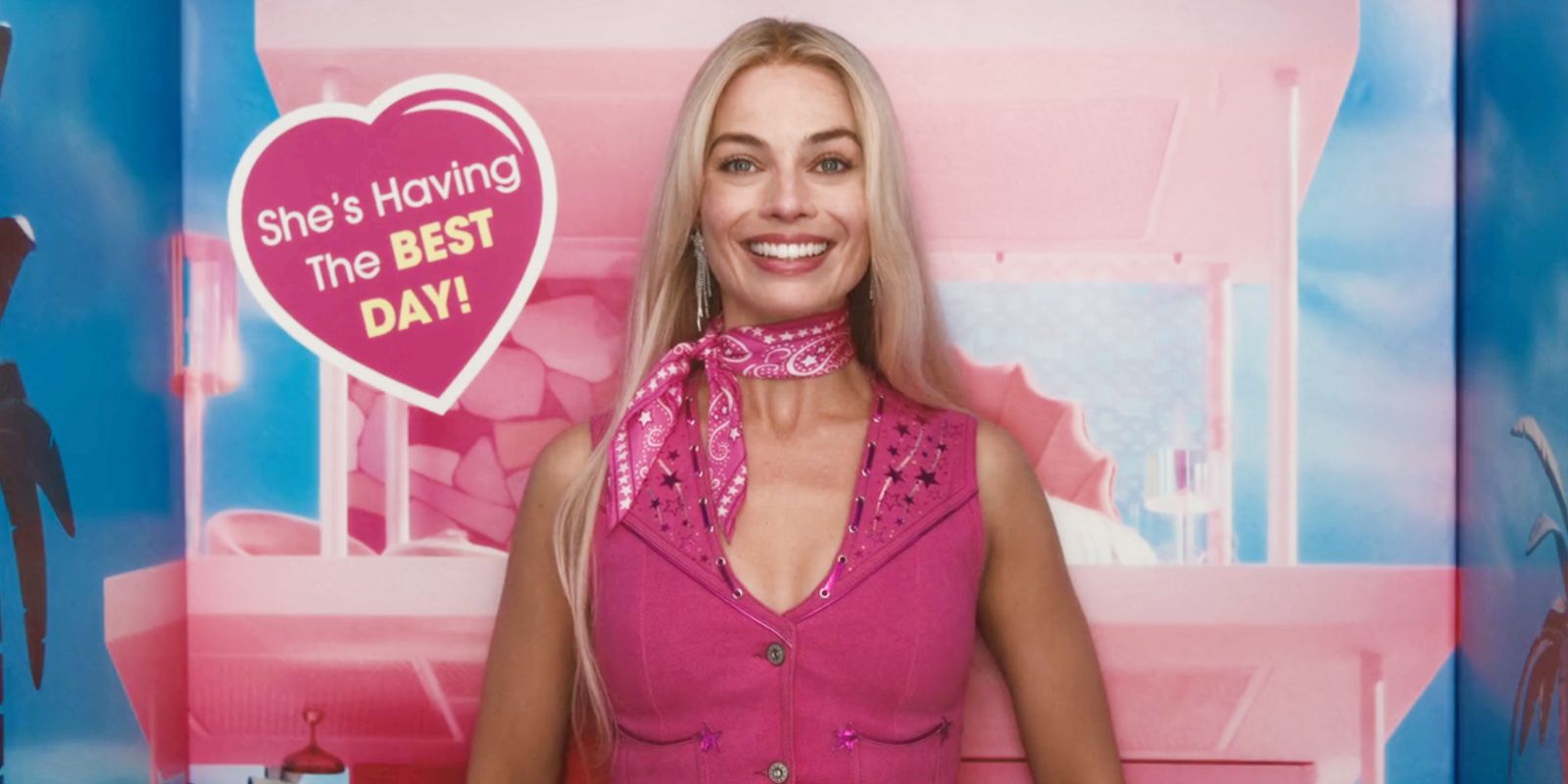 Margot Robbie as Barbie standing in Barbie box while smiling