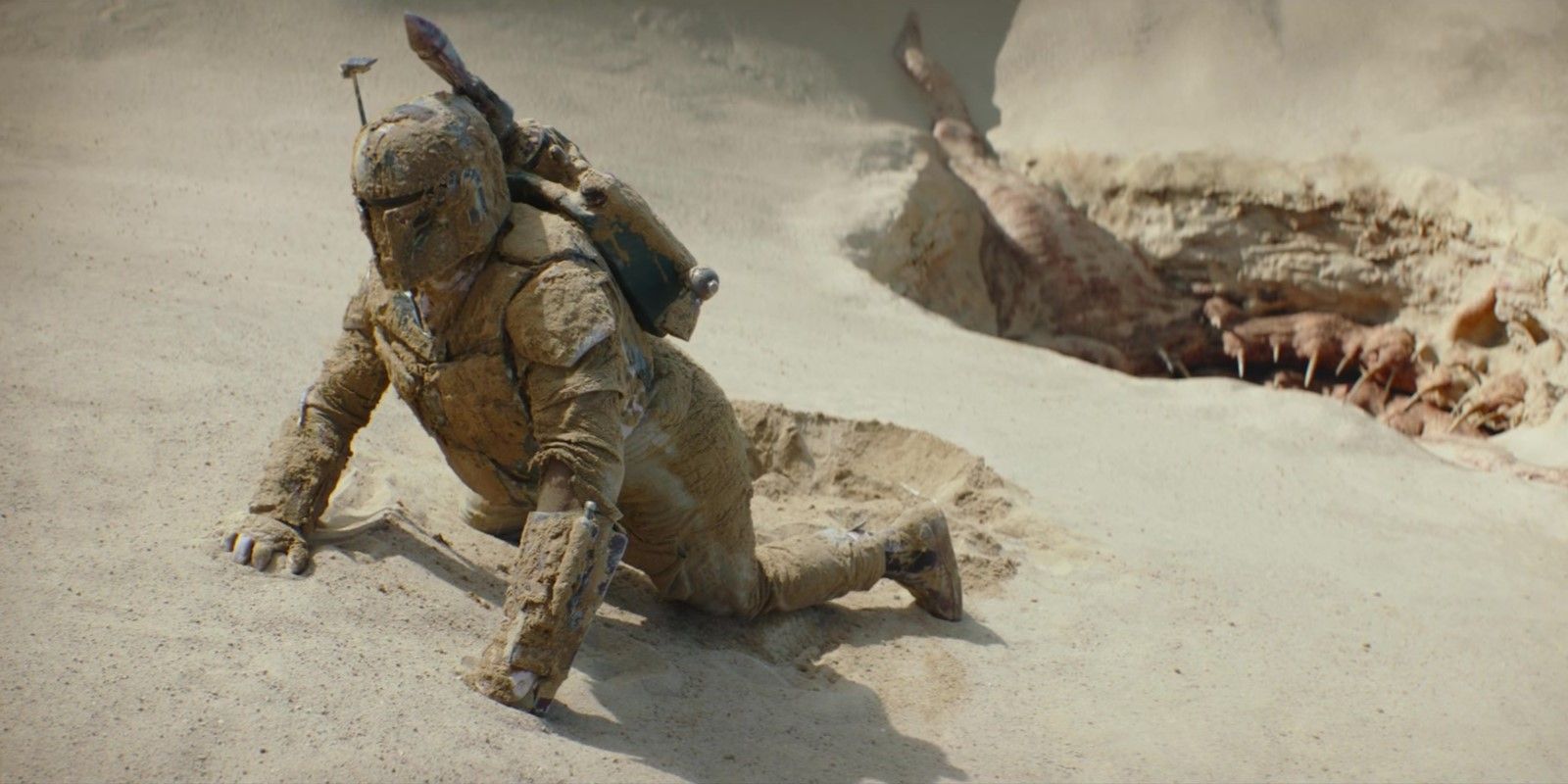 Boba Fett covered in sand, dragging himself out of the sarlacc pit in The Book of Boba Fett season 1 episode 1