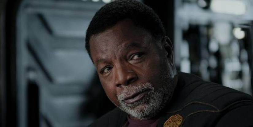 Carl Weaters as Greef Karga looks at someone off-screen in a scene from The Mandalorian.