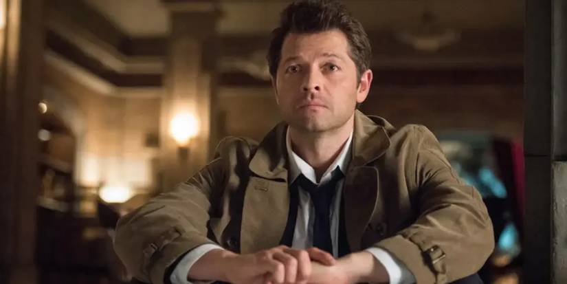 Misha Collins as Castiel, looking sad in Supernatural, sitting down and staring into the distance.