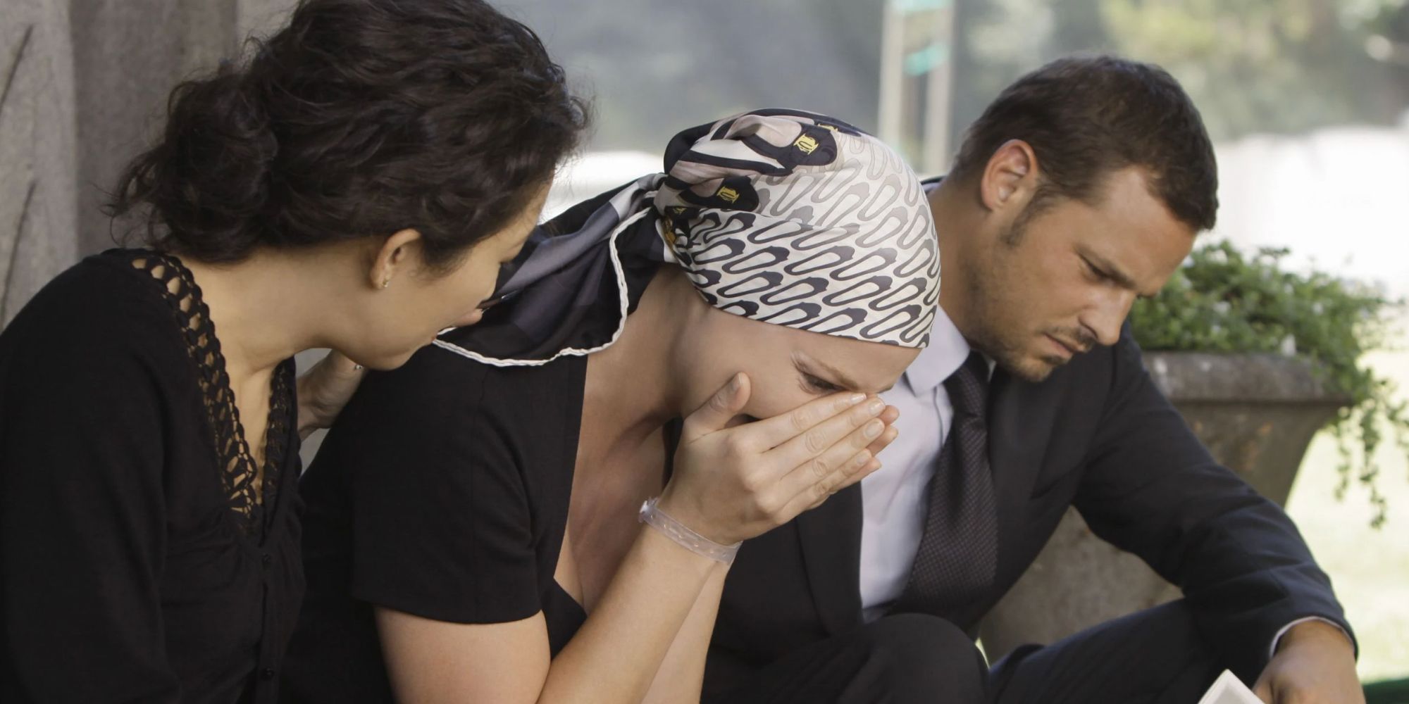 Cristina (Sandra Oh) and Alex (Justin Chambers) comfort Izzie (Katherine Heigl) at George's funeral in Grey's Anatomy