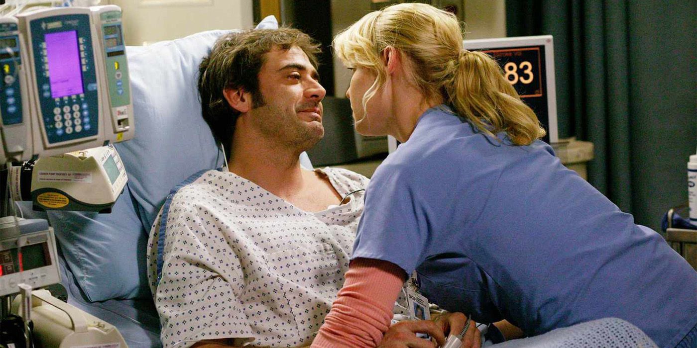 Izzie leaning over Denny in his hospital bed in Grey's Anatomy.