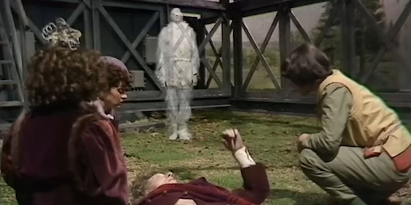 The Watcher approaches the dying Fourth Doctor (Tom Baker) in Doctor Who