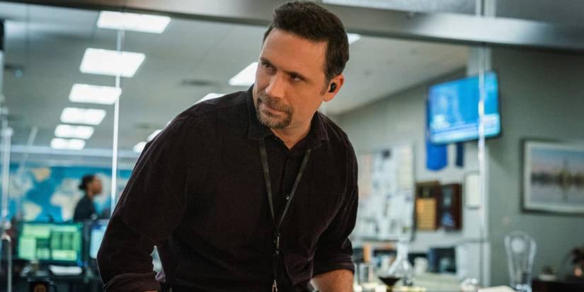 Jubal standing with a phone receiver in his ear in FBI