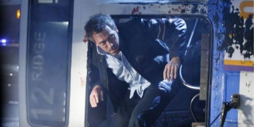 Hugh Laurie como Dr. Gregory House emergindo do ônibus batido, com o rosto ensanguentado e machucado, no episódio de House 'House's Head'.