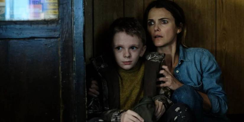 Keri Russell hugs a young boy as they hide in Antlers
