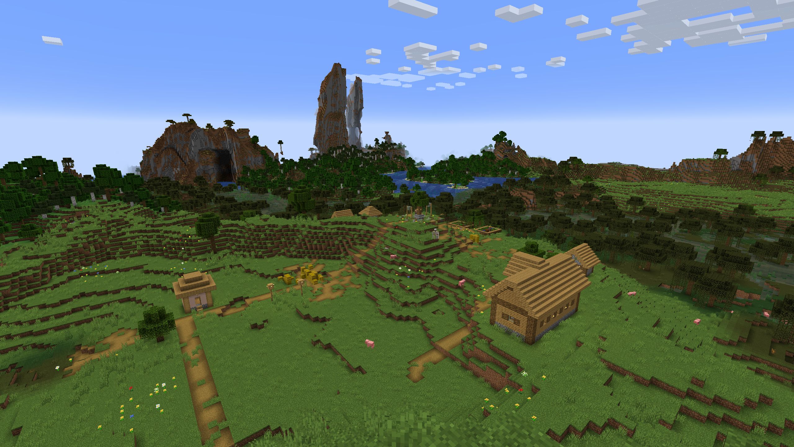 Vila Minecraft em uma encosta na beira de um pântano com dois altos picos de montanha visíveis no horizonte