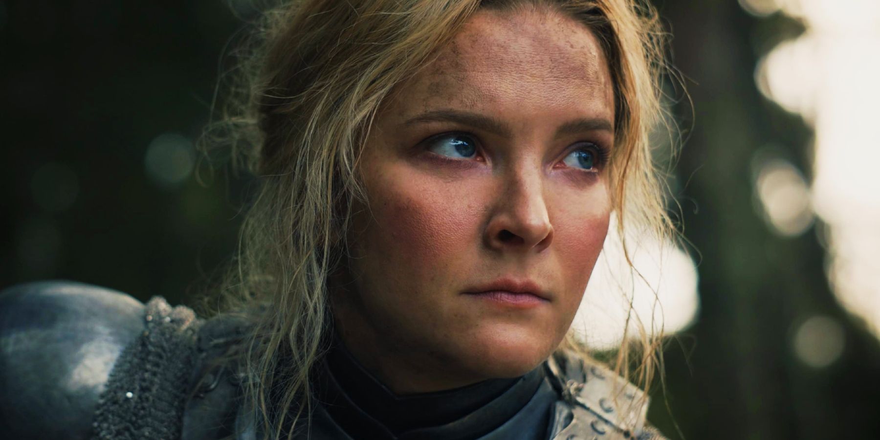 A close-up of Morfydd Clark as Galadriel looking grave in The Rings of Power.