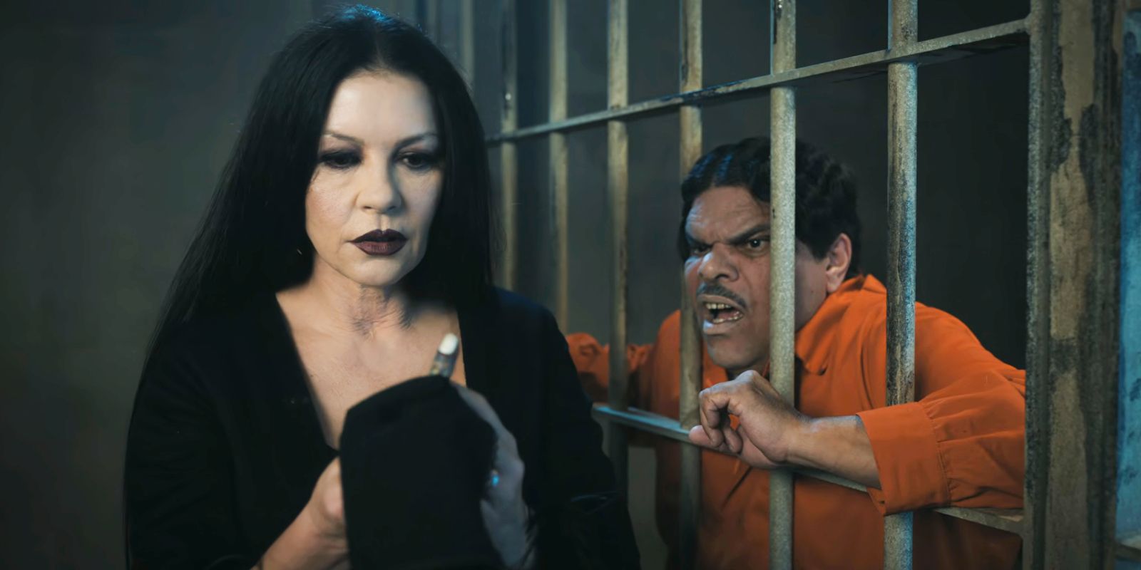 Morticia Addams holding a finger next to a Gomez who is behind bars in Wednesday