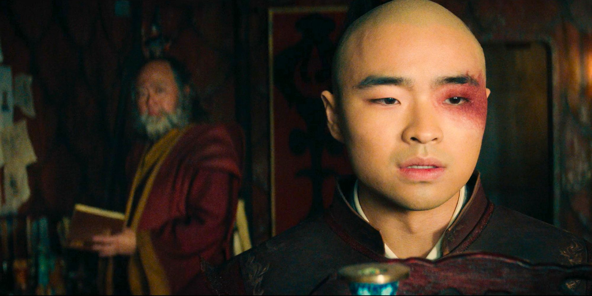 Zuko close up and uncle Iroh in the back from Avatar the last airbender looking gloomy Dallas James Liu as Zuko Paul Sun-Hyung Lee as Uncle Iroh