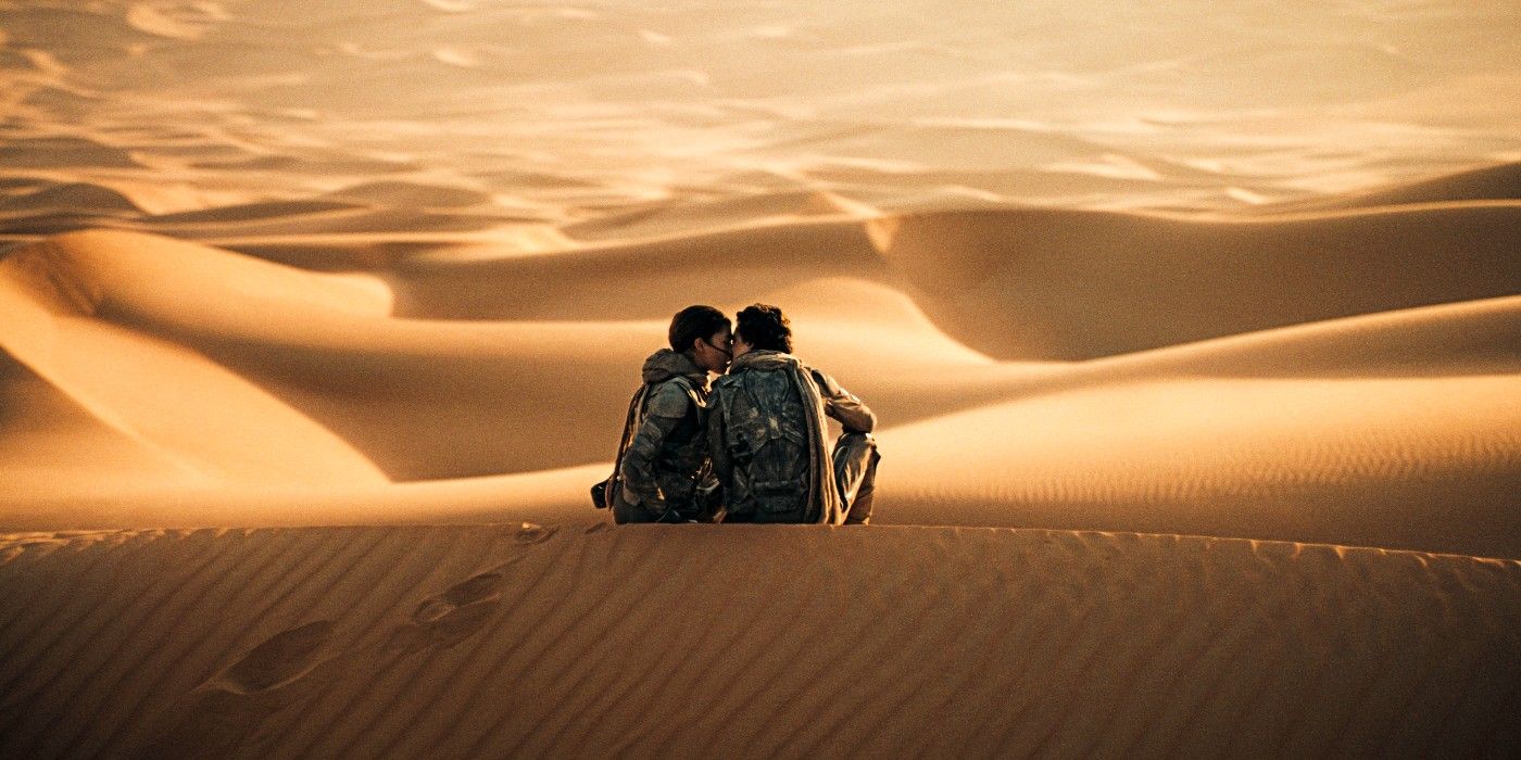 Zendaya as Chani and Timothée Chalamet as Paul kissing in a desert in Dune: Part Two. 