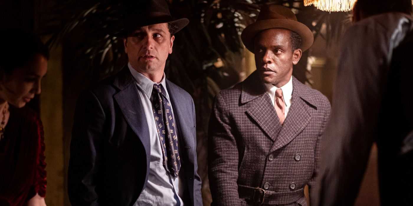 Pete (Shea Whigham) and Paul (Chris Chalk) looking at someone in a bar together in Perry Mason.