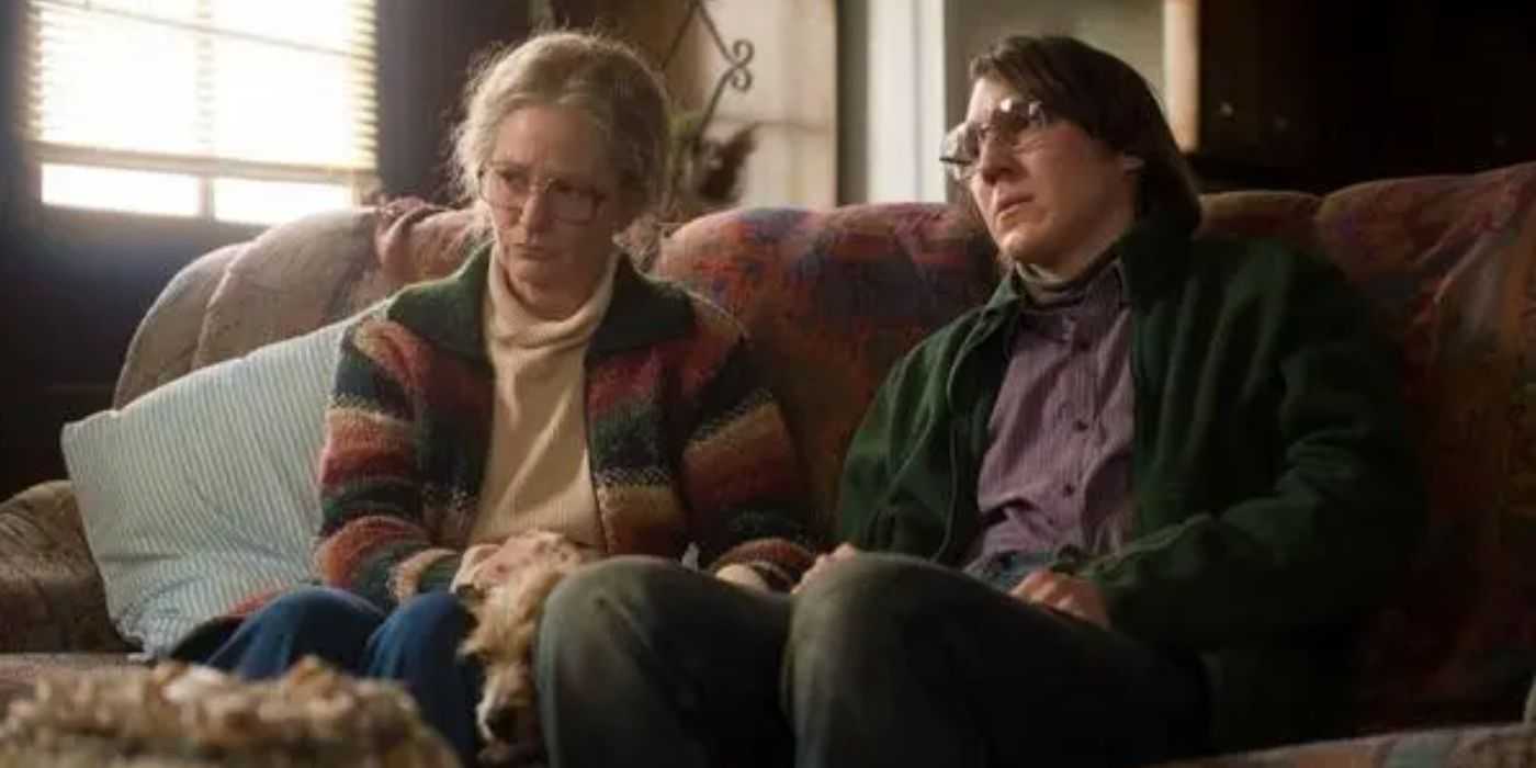 Melissa Leo as Holly and Paul Dano as Alex looking serious on a couch in Prisoners (2013)