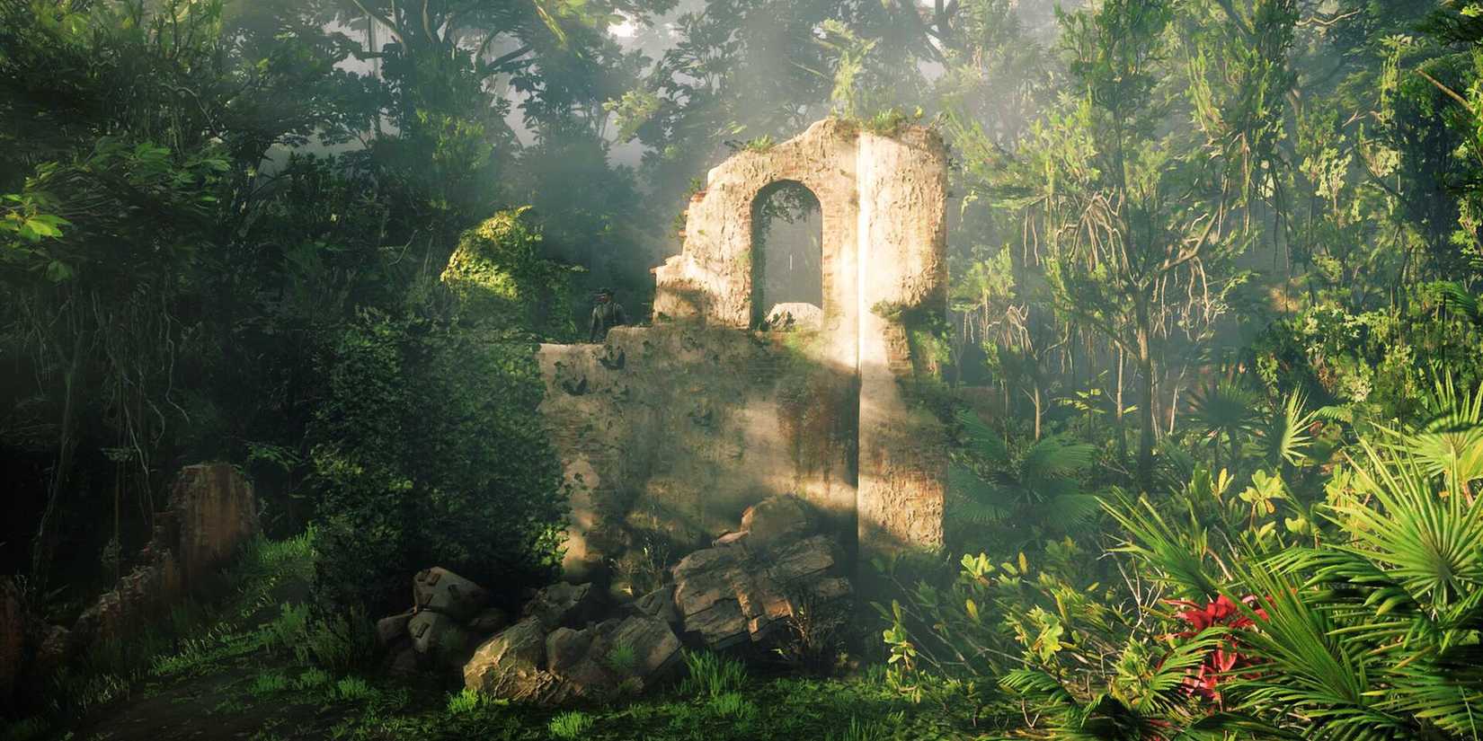 Ruins of a stone building lie amid thick jungle, lit unevenly by sun filtering through leaves, in a screenshot from Red Dead Redemption 2. 