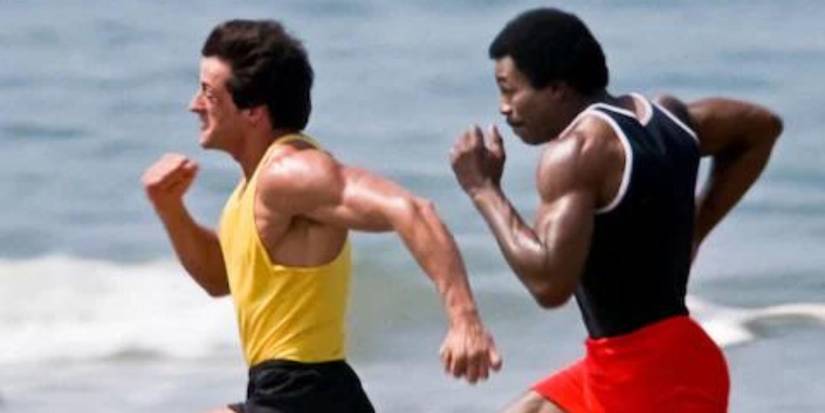 Sylvester Stallone as Rocky Balboa and Carl Weathers as Apollo Creed sprint on the ocean in Rocky III.
