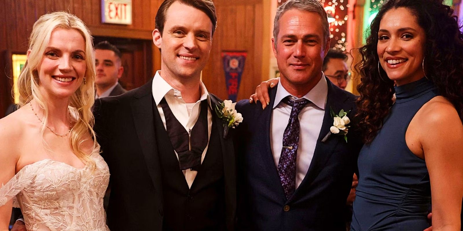 Sylvie Brett, Matt Casey, Kelly Severide, and Stella Kidd posing and smiling at the wedding in Chicago Fire