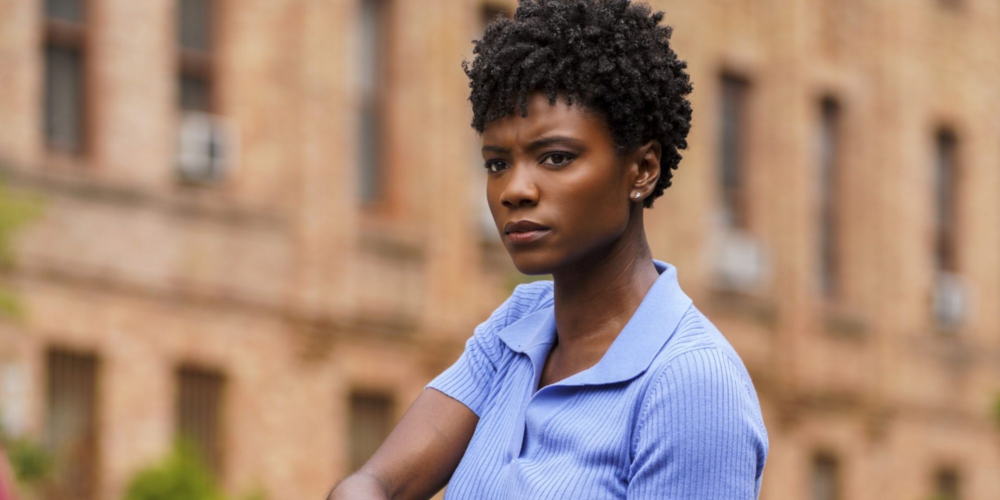 Tiffany Wallace wearing a lilac-collared shirt as she makes a stern star in FBI