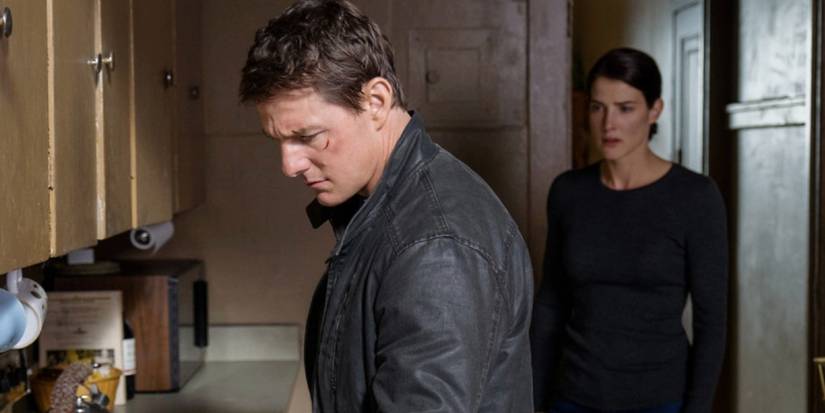 Tom Cruise as Jack Reacher looking down at a kitchen counter with Cobie Smulders as Susan Turner in the background in Jack Reacher: Never Go Back