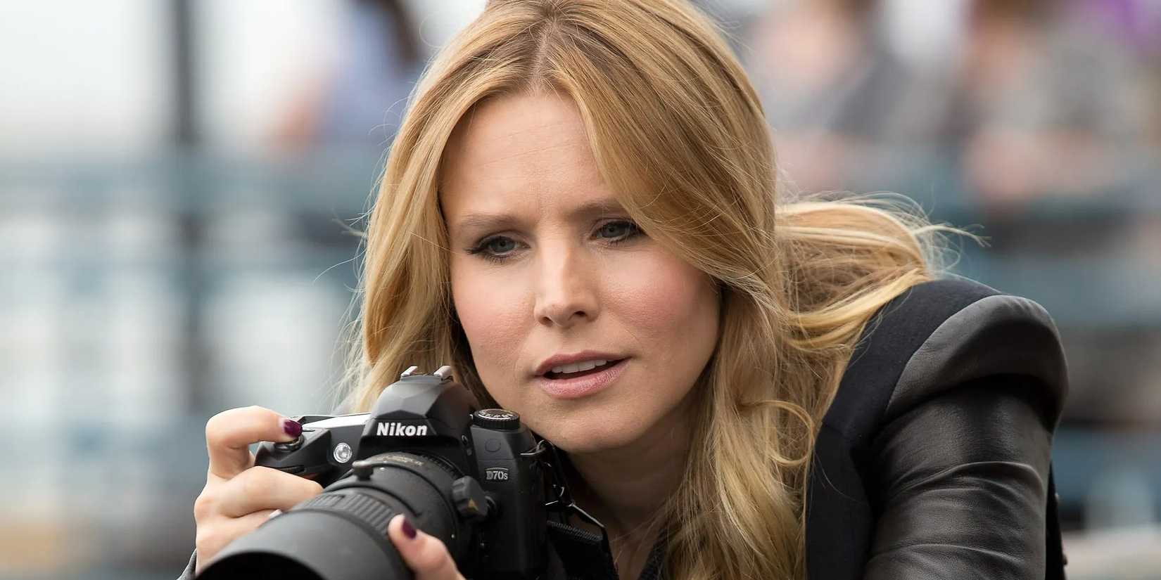 Veronica Mars holding a camera looking surprised