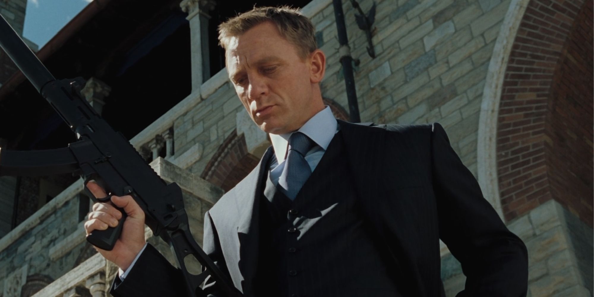 Daniel Craig as James Bond casually holding a gun in Casino Royale
