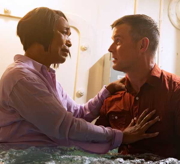 Angela Bassett as Athena Grant-Nash and Peter Krause as Bobby Nash holding each other in a flooding room in 9-1-1 season 7.