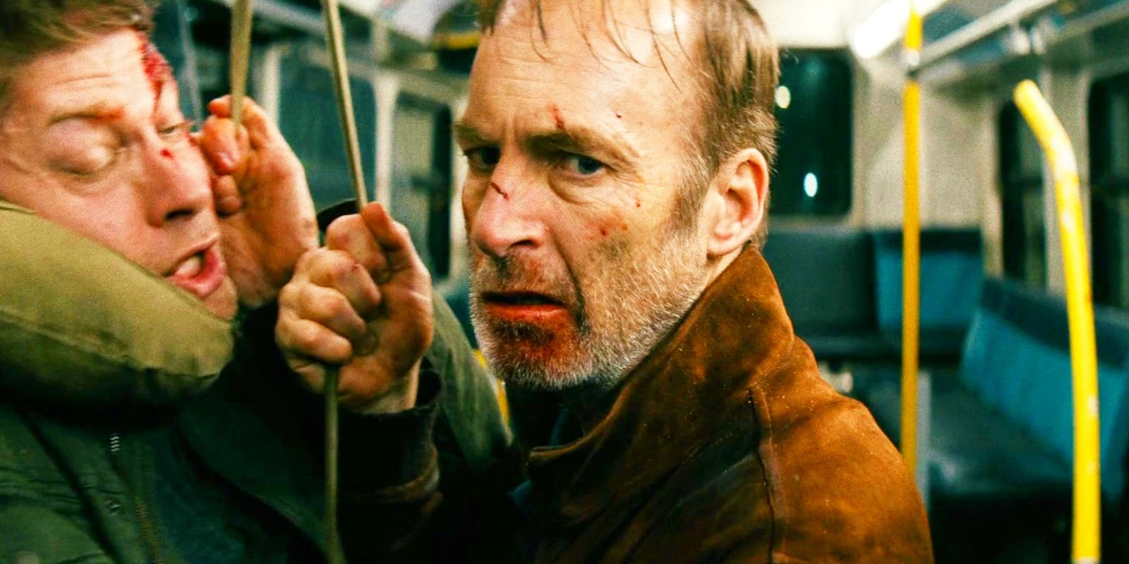 Bob Odenkirk as Hutch punching a man in the face on a bus in Nobody