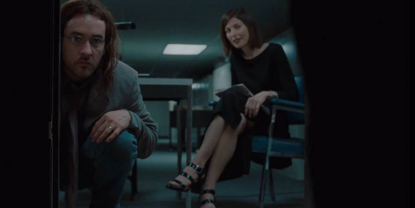 John Cusack as Craig looking in the pᴀssage and and Catherine Keener as Maxine watching behind in Being John Malkovich