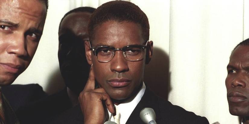 denzel washington as malcolm x is surrounded by reporters of nation of islam members in malcolm x