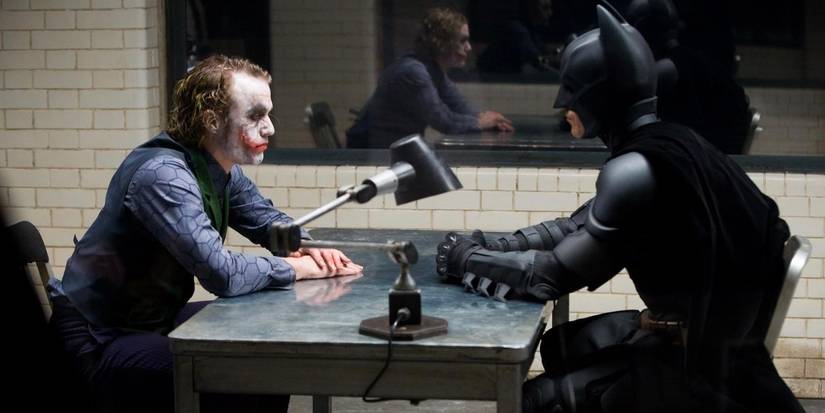 Heath Ledger and Christian Bale sitting down across from one another. 