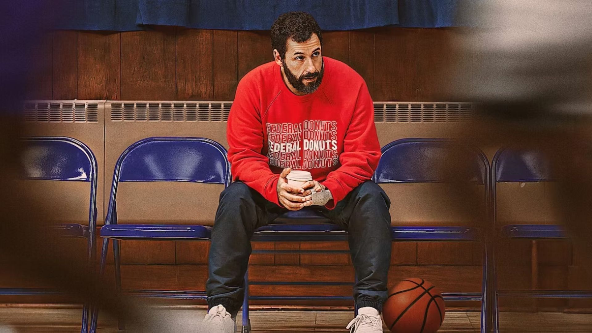 Adam Sandler's Stanley Sugerman in Hustle sitting in the bleachers