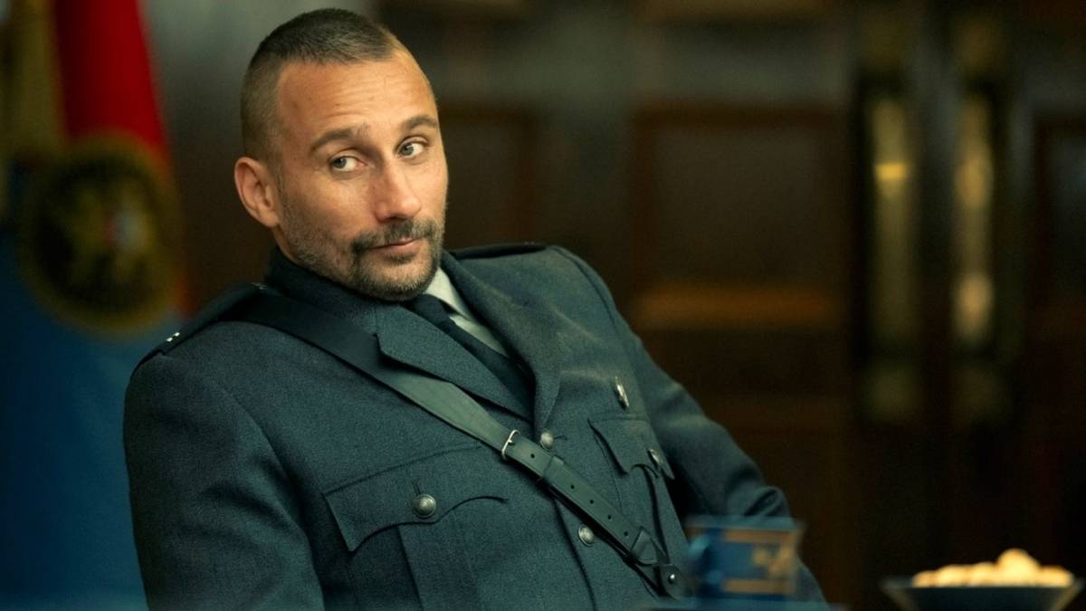 Matthias Schoenaerts smirking as Zubak while wearing a uniform in The Regime
