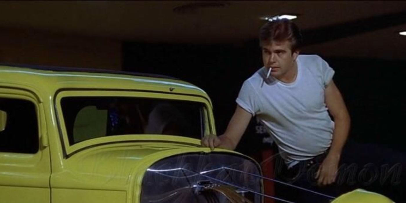John Milner standing by a yellow car in American Graffiti