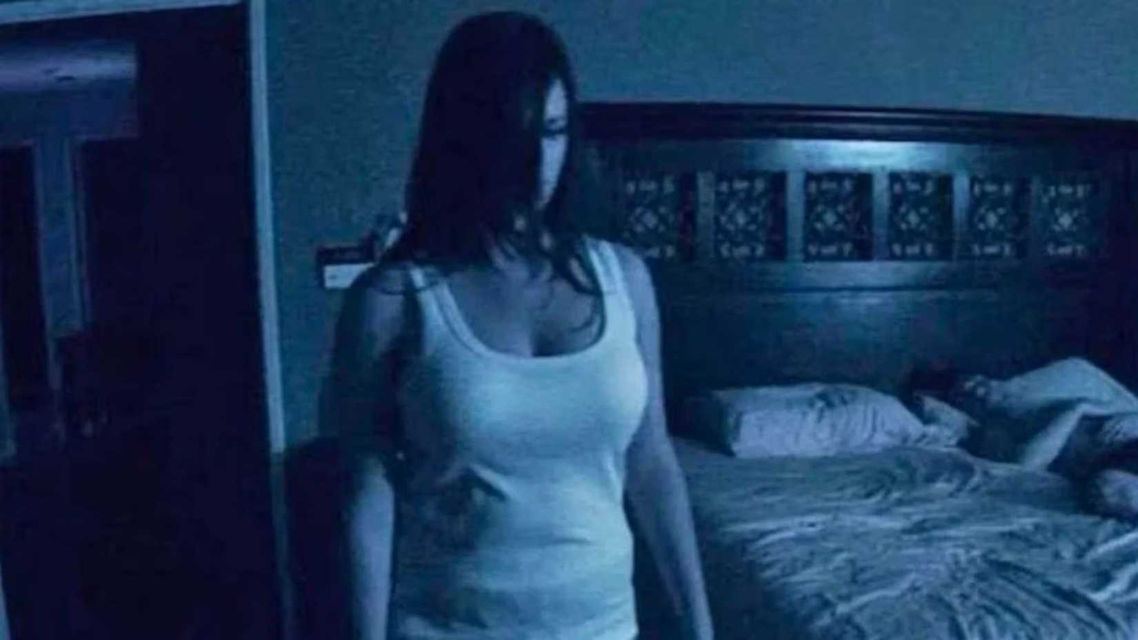 Katie Featherston em pé com o cabelo no rosto em Atividade Paranormal.