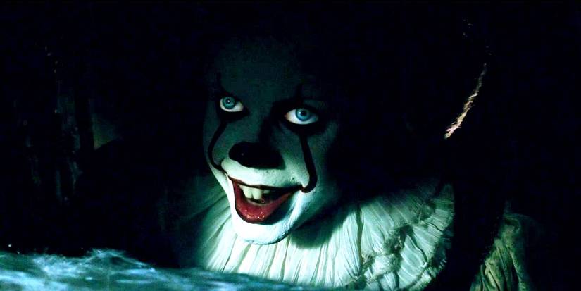 Pennywise sorrindo nas sombras do bueiro em It (2017)
