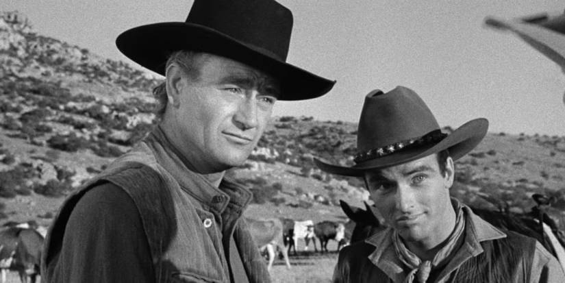 John Wayne in Red River with his co-star, both in cowboy outfits with hills in the background