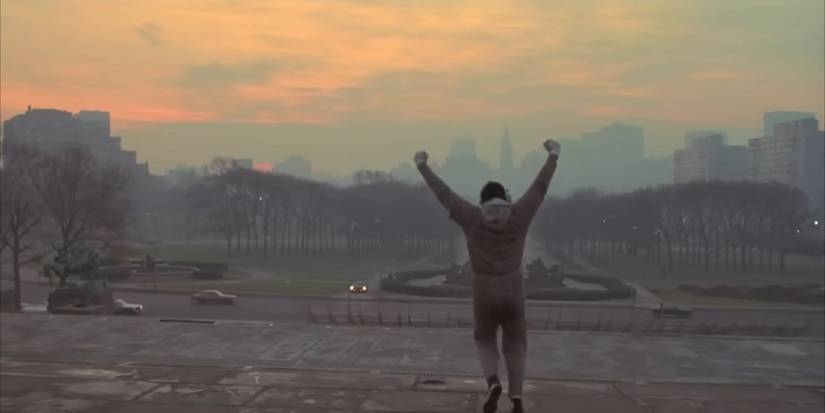 Rocky celebrating at the top of the steps in Rocky (1976)